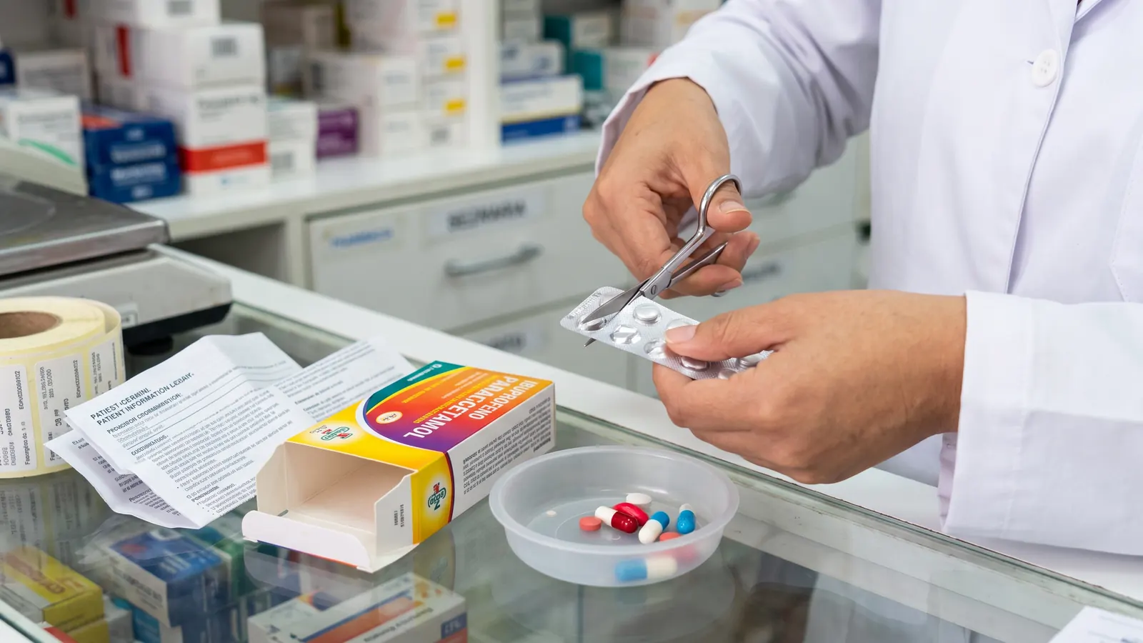 Farmacéutico cortando un blíster de tabletas para vender pastillas sueltas